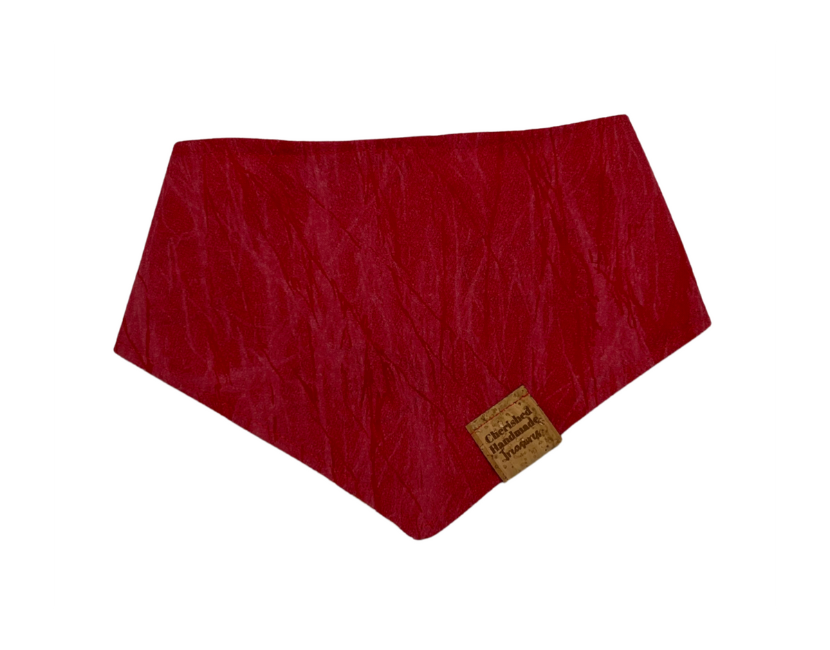 A red crinkled fabric bandana with a small cork brand tag, shown on a plain white background.