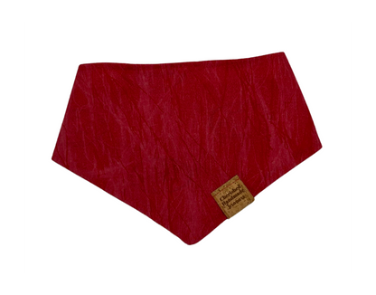 A red crinkled fabric bandana with a small cork brand tag, shown on a plain white background.